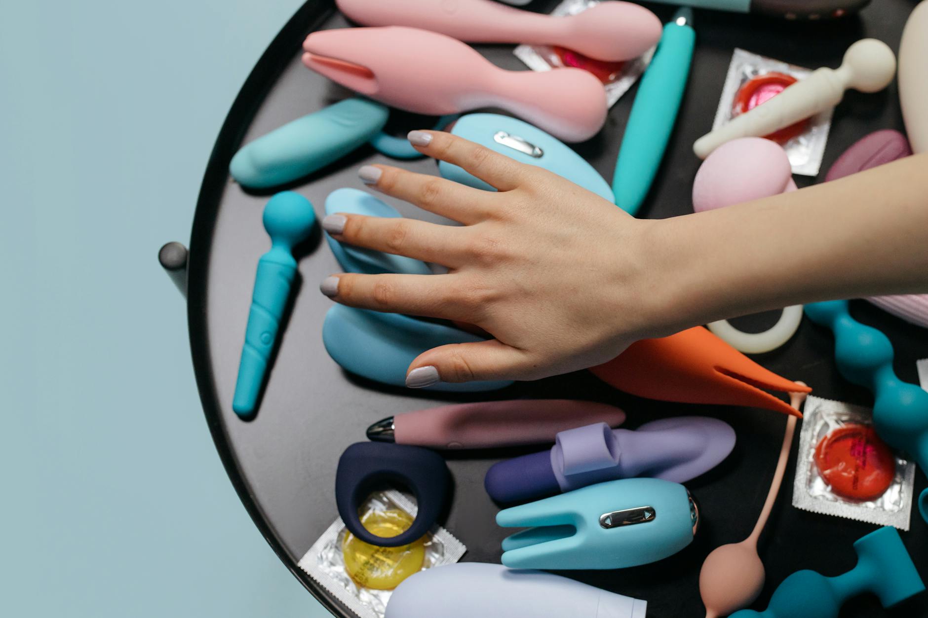 A collection of colorful sex toys displayed together on a soft surface.