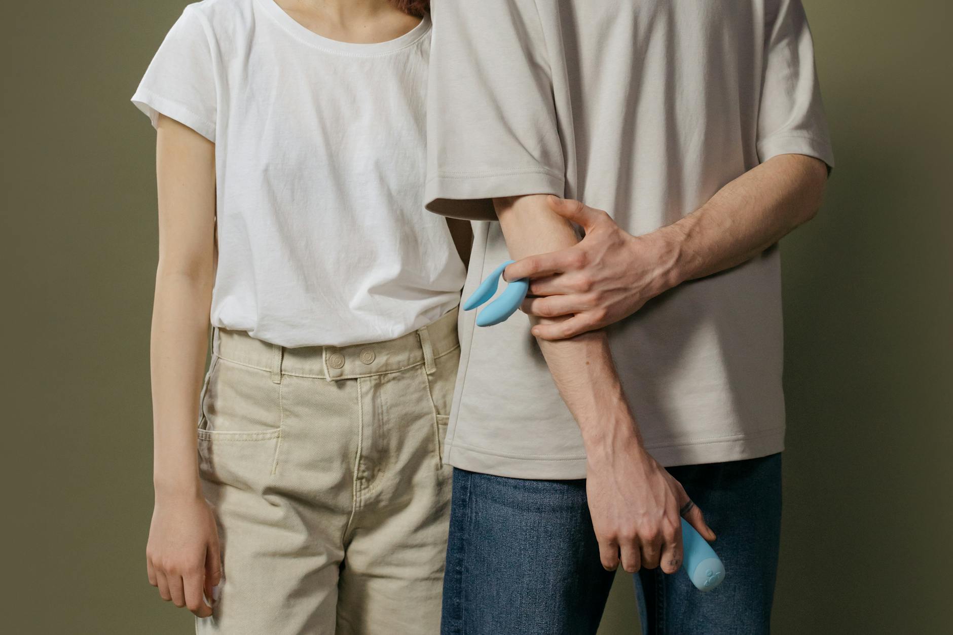 A clitoral vibrator held in hand against a purple background, representing modern pleasure and self-care