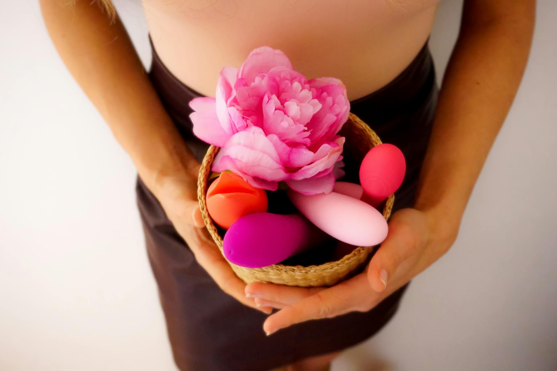 A silicone vibrator held in hand against a purple background, symbolizing reclaiming sensation and self-pleasure